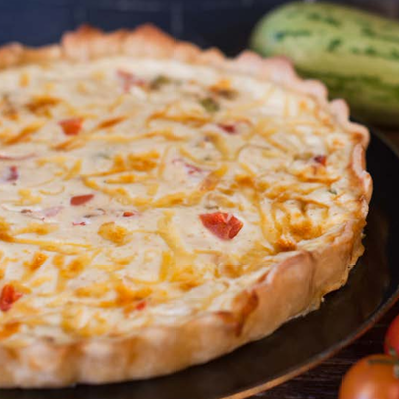 Quiche de alho-poró servida em fatia.