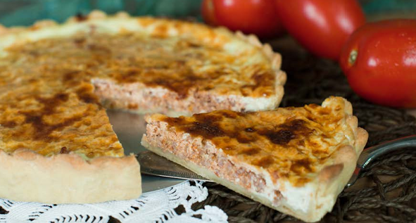 Fatia de quiche dourada servida em uma mesa.